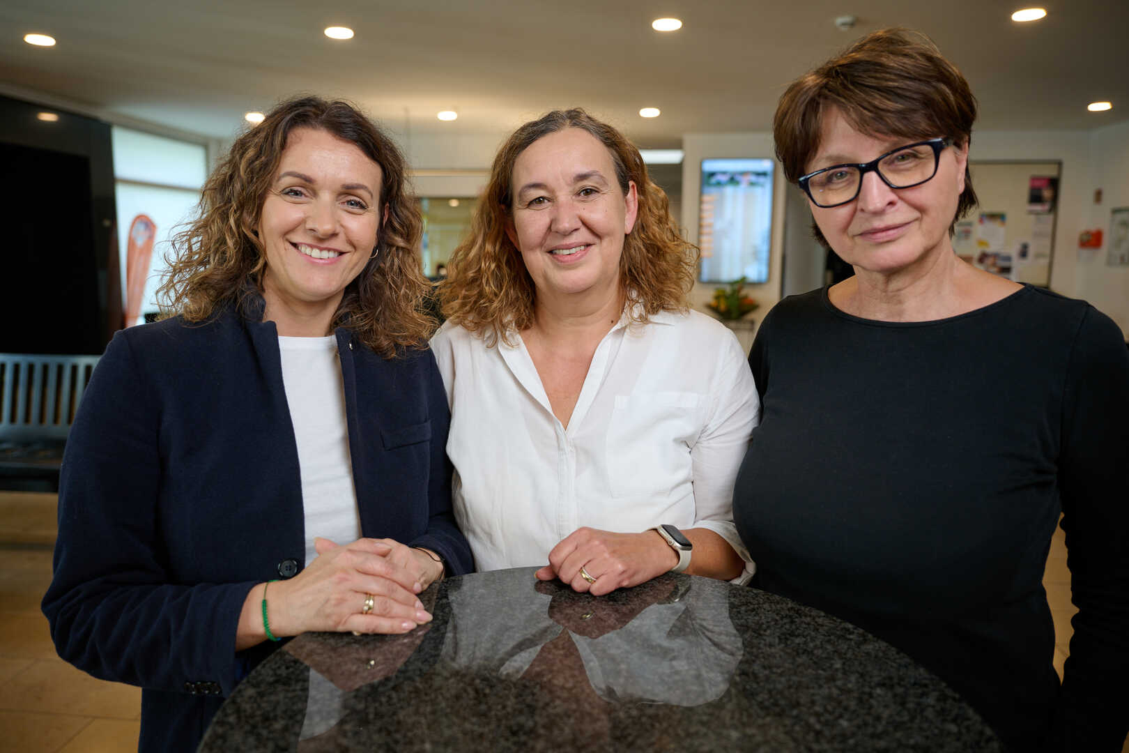 Drei Frauen stehen nebeneinander an einem Stehtisch im KönzgenHaus